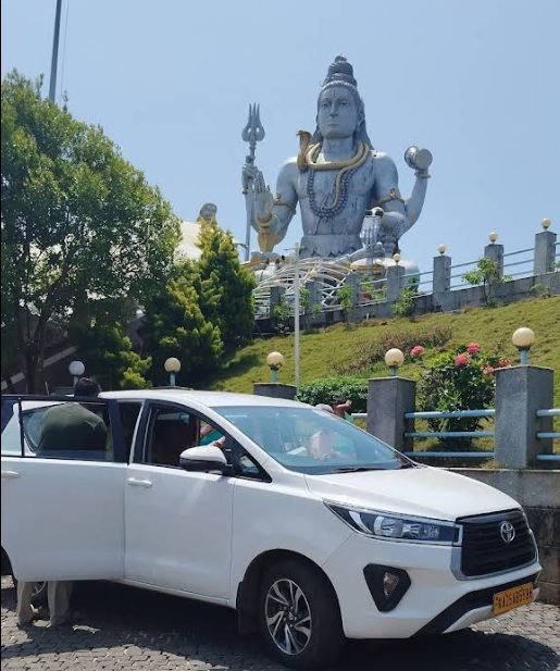 Toyota Innova taxi parked at the Murudeshwar Shiva statue